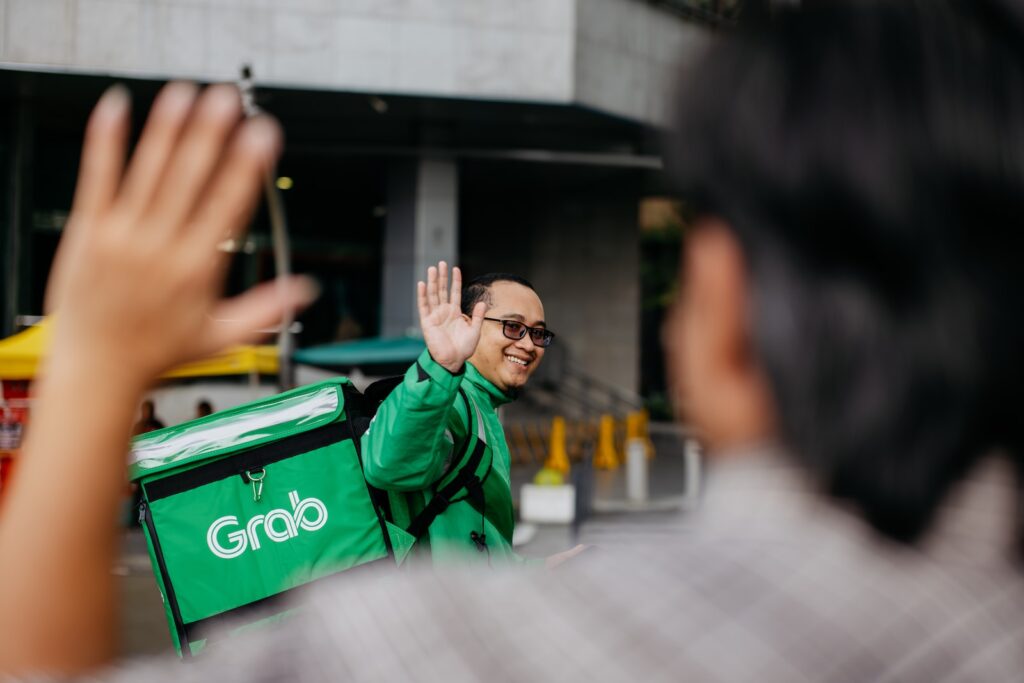 a man in a green jacket waving to someone